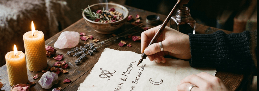 Hand writing a romantic note on parchment with quill and ink